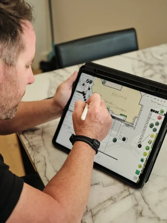 Landscape plan drawn on a tablet with a stylus at a marble table